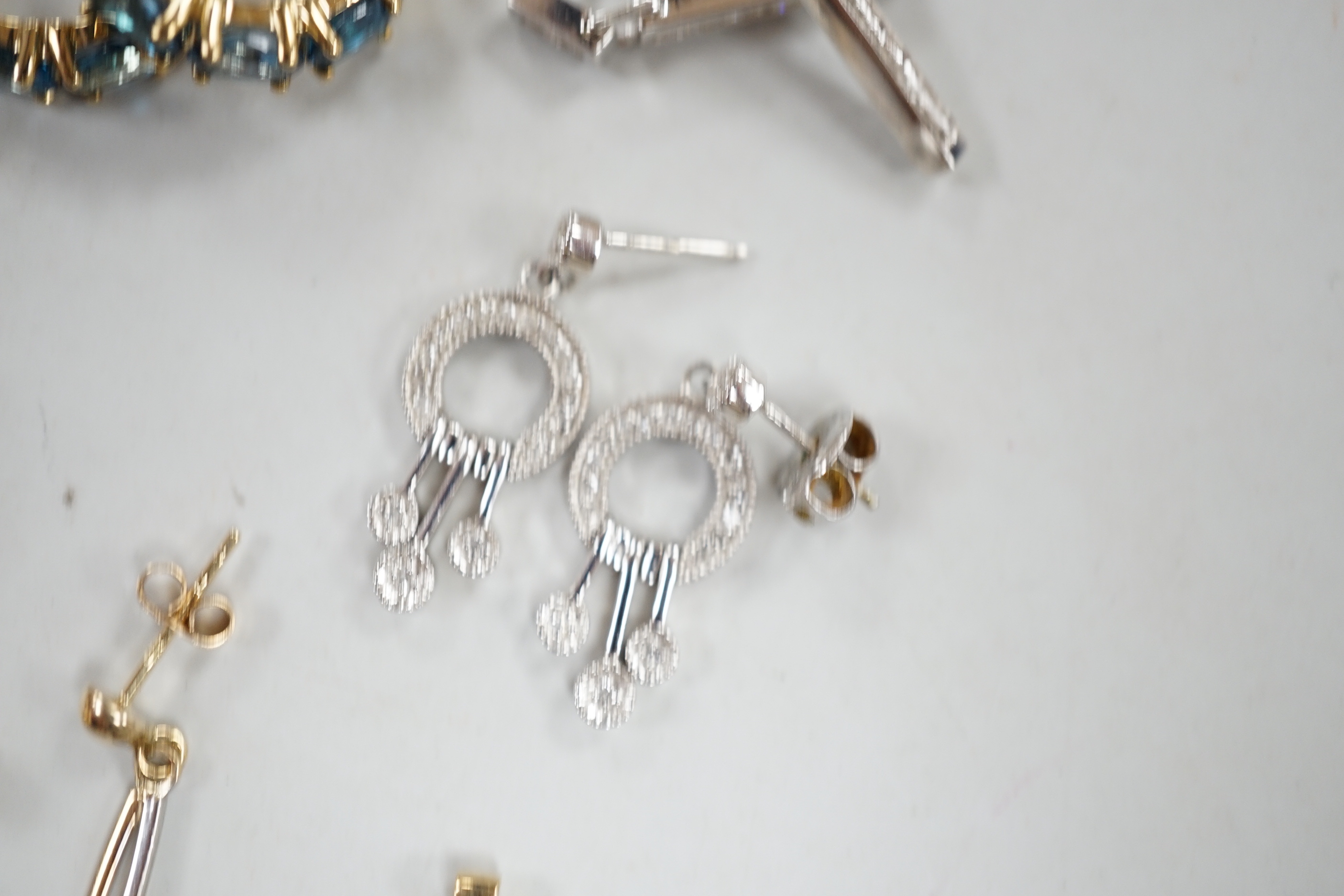 Five assorted modern pairs of 9ct and gem set earrings, including diamond chip cluster drop and blue topaz set demi lune, together with three assorted modern 9ct or yellow metal and gem set small pendants, gross weight 1